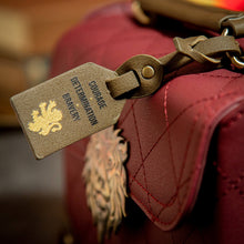 Load image into Gallery viewer, Bag Tag displaying &#39;Courage, Determination and Bravery&#39;, attached to the Gryffindor Trunk Bag 