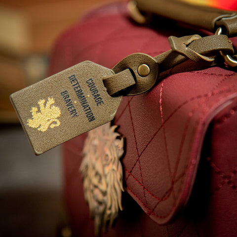 Bag Tag displaying 'Courage, Determination and Bravery', attached to the Gryffindor Trunk Bag 